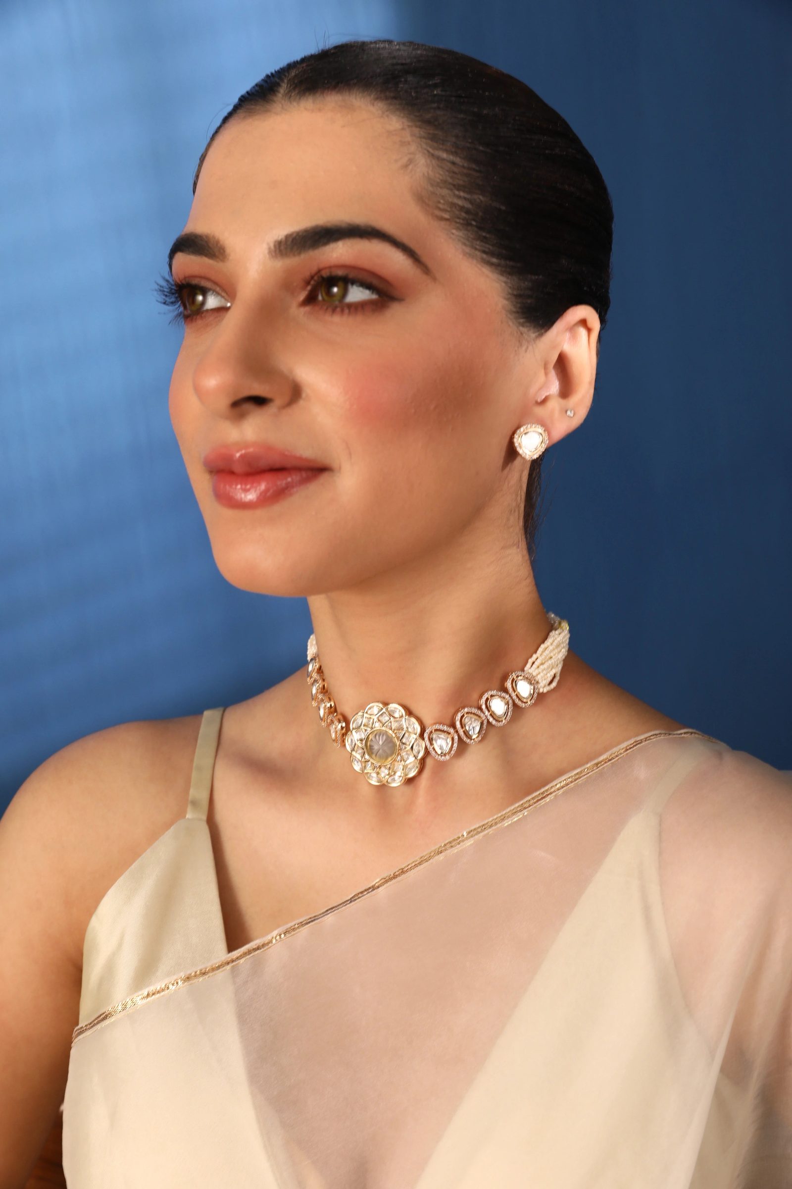 Polki choker and stud earrings worn with an ivory silk saree