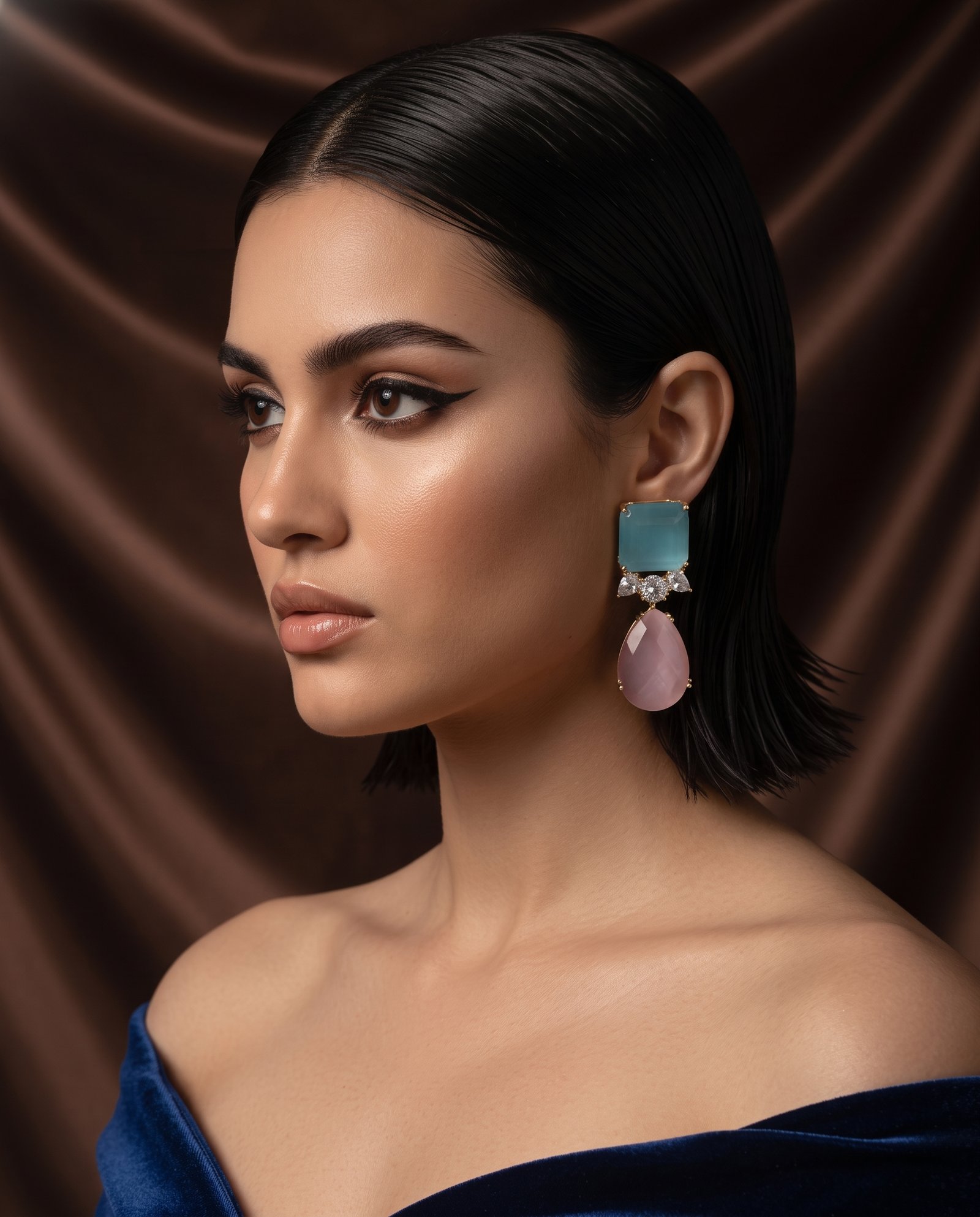 A woman in a navy off-shoulder dress wearing Aqua Rosé Cascade drop earrings
