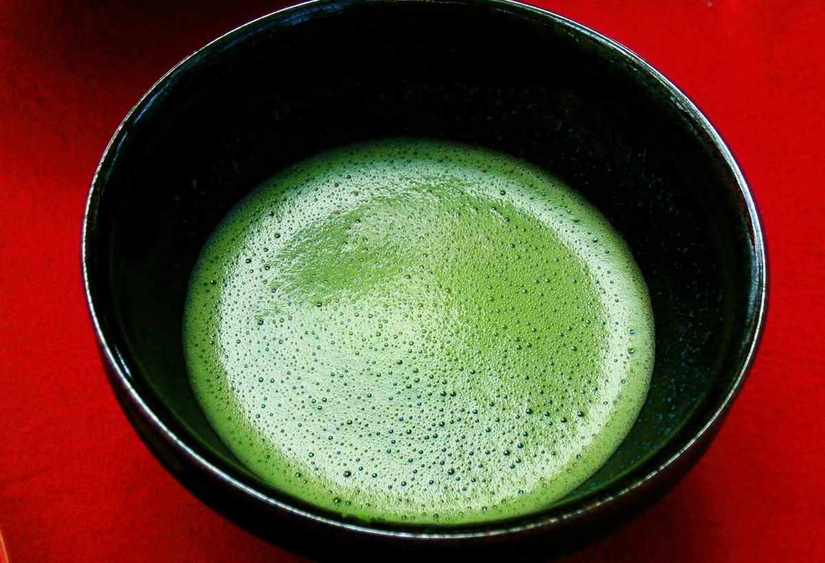 Foamy whisked matcha in a black tea bowl