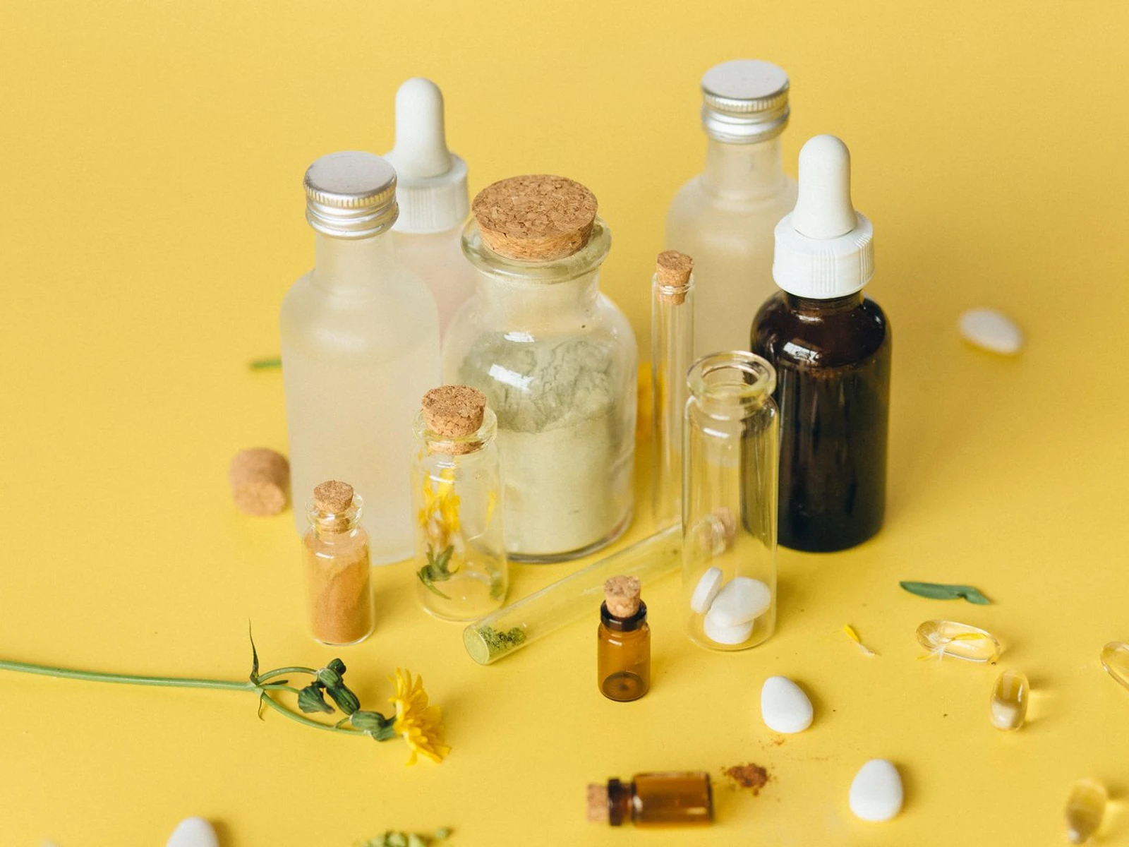 Unbranded supplement bottles, capsules, and botanical materials in a real tabletop still life